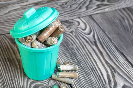 Trash can with lid filled with waste batteries. The batteries are covered with corrosion. Close-up shot. Symbol of environmental protection day.の写真素材