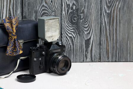 Photographer accessories. Camera and flash. There is a bow tie on the camera. Against the background...