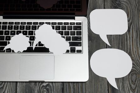 Speech bubbles on a background of brushed pine boards. The bloggerâ€™s laptop keyboard is...