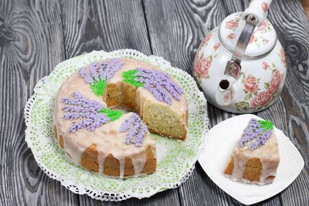 Lavender Cupcake. Sugar coated. Decorated with lavender glaze flowers. A small piece is cut off....
