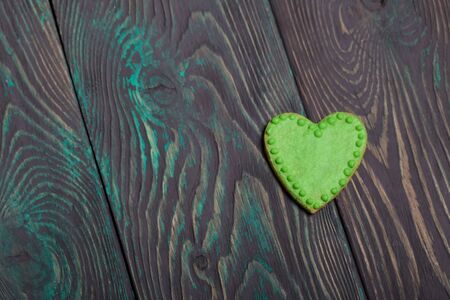 Gingerbread decorated with glaze. Made in the shape of a heart. On brushed pine boards.の写真素材