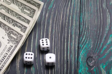 Dice are white. Near dollars. On brushed pine boards.