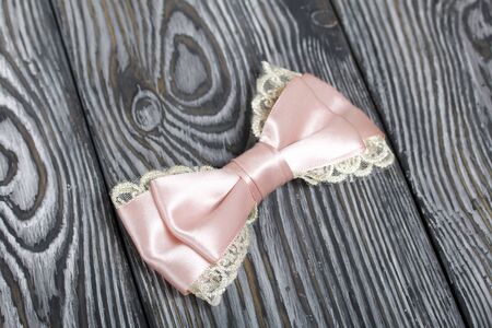 Hair clip made of pink ribbon. On pine boards painted black and white.の写真素材