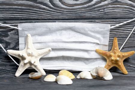 Starfish and shells are scattered on pine boards painted in black and white. Nearby is a medical...