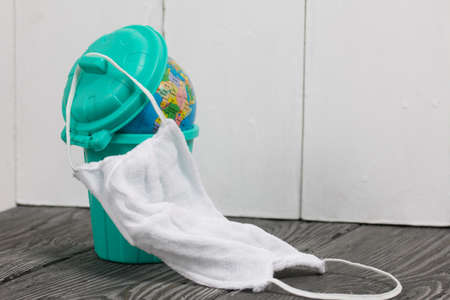 Garbage container with a globe. He is wearing a protective mask during a pandemic.の写真素材