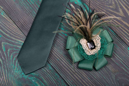 Men's tie and women's brooch. Accessories for spouses. Love and Togetherness Objects. On painted boards.の写真素材