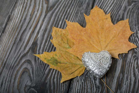 Decorative candle in the shape of a heart. Dried maple leaves. Love and Togetherness Objects. On...