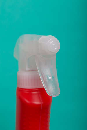 Red plastic bottle with spray. Cleaning spray. On a mint background.の写真素材