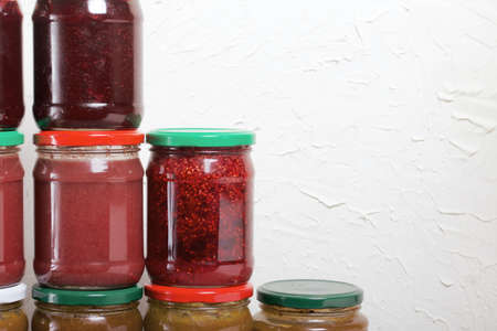 Jam in glass jars. It stands in the form of a pyramid against the background of a light wall.の写真素材