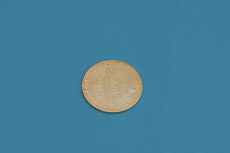 Gold bitcoin on a green background.