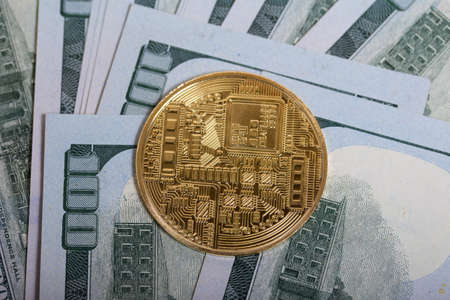 Golden bitcoin among dollar bills.