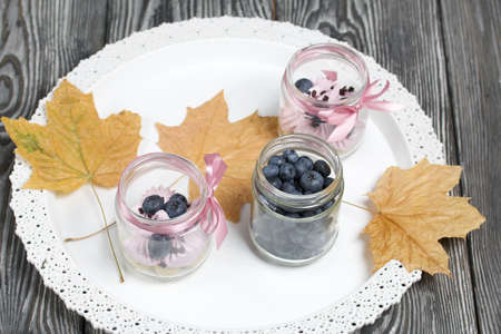 Zephyr in a jar, decorated with blueberries and dried maple leaves. On a tray.の写真素材