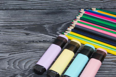 Colored pencils and colored markers. On brushed pine boards painted black and white.の写真素材
