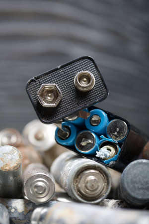 Corroded used batteries. On pine boards. Disposal of hazardous waste. Close-up shot.