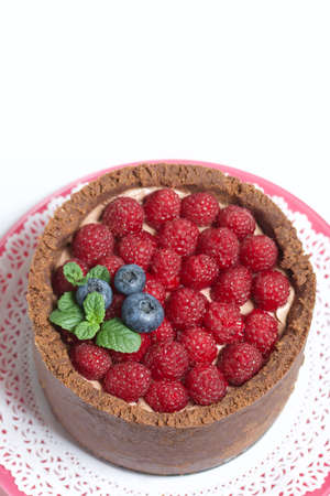 No-bake chocolate cake with cream cheese. Garnished with raspberries, blueberries and mint leaves....