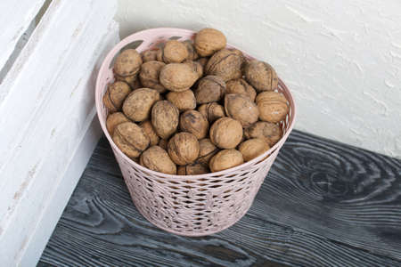 A basket with walnuts. Nearby is a white wooden box.