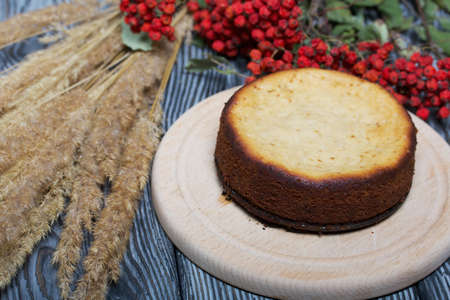 Freshly baked cupcake on a chalkboard. Nearby is a dried rowan branch with red berries and a bouquet...