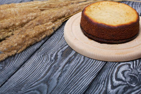 Freshly baked cupcake on a chalkboard. Nearby is a bouquet of dried grass. Against the background of...