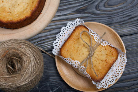 Freshly baked cupcake on a napkin. Tied with twine. Next to the second cupcake and a reel of rope....