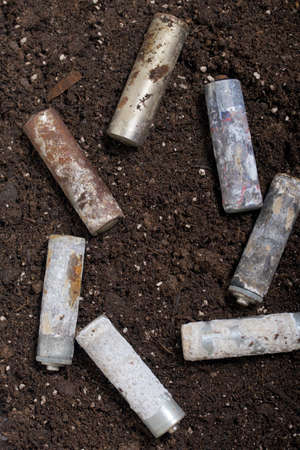 A corroded battery is lying on the ground. Environmental protection and waste recycling. Close-up...