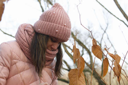 Girl in autumn clothes. Walking in nature in the park.