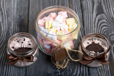 Marshmallow in a jar. With cookies and chocolate. On pine boards.の写真素材