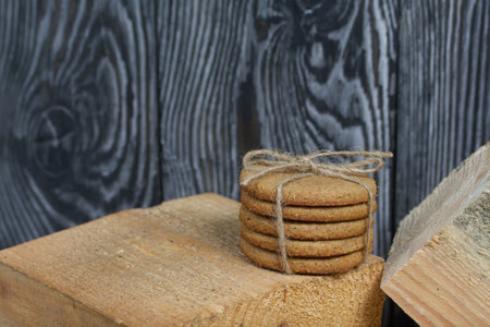 Gingerbread cookies tied with twine. Nearby are wooden blocks. On boards painted white.の写真素材