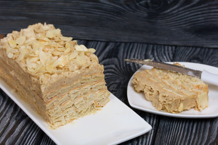 Puff pastry cake. With banana cream and almond petals.