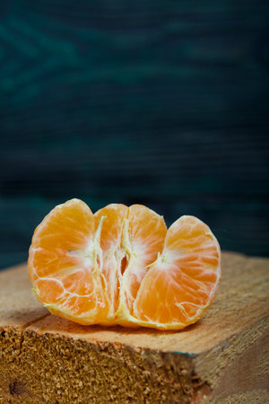 Tangerine without peel. Lies on a wooden block. Close-up shot.の写真素材