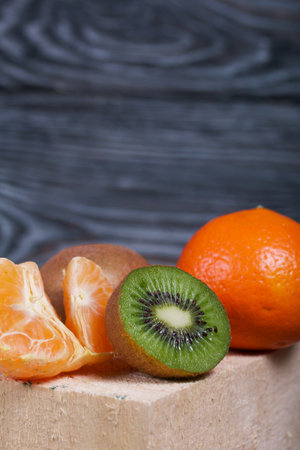 Orange tangerines. One without a peel. Kiwi fruit cut in half. Juicy green flesh is visible. Close-up shot.の写真素材