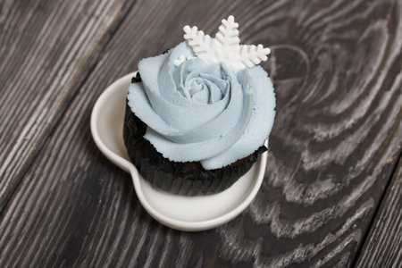 Muffin with cream cheese cream. Decorated with a marshmallow snowflake.の写真素材