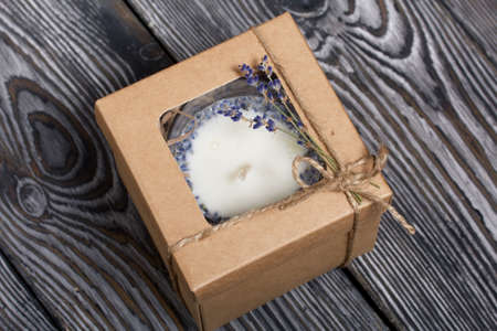 Decorative candle in craft packaging. Tied with a cord and decorated with lavender branches.の写真素材