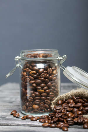 Coffee beans. Poured into a drag bag jar and linen bag. Close-up shot.