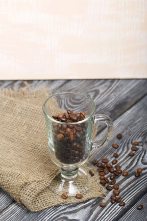Coffee beans. Poured into a glass beaker. Stands on linen and pine boards.の写真素材