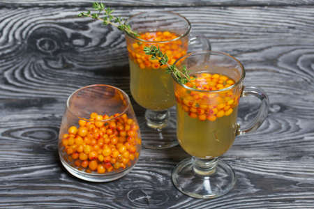 Cocktail with sparkling wine and sea buckthorn. Sea buckthorn bellini. Decorated with thyme sprigs.の写真素材