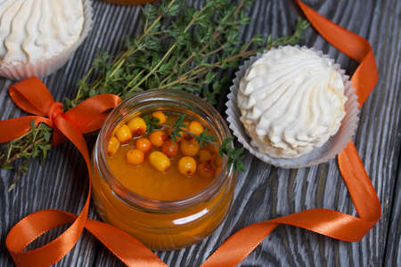 Sea buckthorn jelly. Decorated with sea buckthorn berries and thyme. Nearby is sea buckthorn...