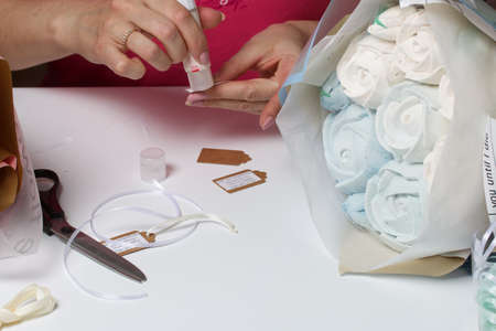 A woman is packing zephyr bouquets in wrapping paper. Tulips and roses from zephyr.