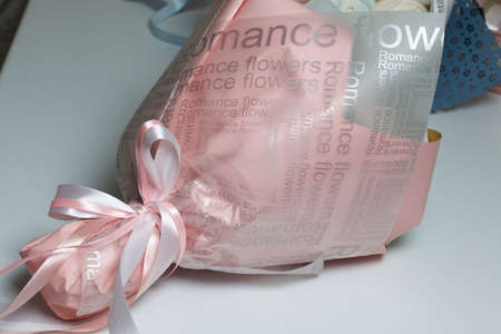 Bouquet wrapped in wrapping paper. Tied with a ribbon tied to a bow.の写真素材