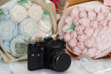 Zephyr bouquet in wrapping paper. Tulips and roses from zephyr. A vintage camera lies nearby.の写真素材