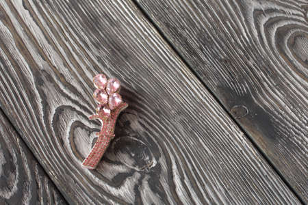 Handmade brooch. Pink color. Lies on pine boards.の写真素材
