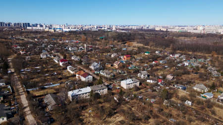 Aerial view of the cityscape. High-rise buildings on the horizon. In the foreground are one-story houses. The river is visible.のeditorial素材