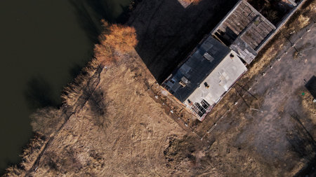 Flight over the city park in the spring. The river is visible. Below are the ruins of an old building.の写真素材