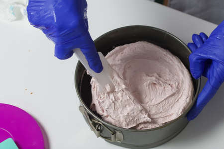 A woman prepares a marshmallow cake. Places a layer of jelly and marshmallows on the biscuit. Works...