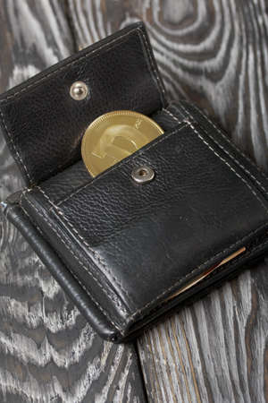 Cryptocurrency coin in an open wallet. On brushed pine boards.の写真素材