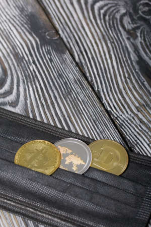 Coins of various cryptocurrencies. Lie on a medical mask. On brushed pine boards.の写真素材