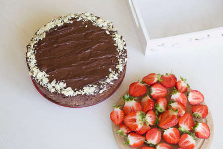 Chocolate cake with peanuts and strawberries. The process of making a cake.の写真素材