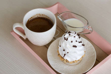 Cake Basket. With chocolate and cream. Nearby is a cup of coffee and milk. Close-up shot.