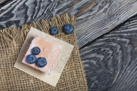 Portion marshmallow on linen fabric. Decorated with blueberries. Close-up shot.