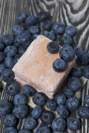 Blueberries are scattered on pine boards. Portion marshmallow. Close-up shot.の写真素材