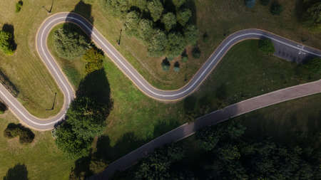 A winding bike path in the park. Winds among trees and bushes. Aerial photography.